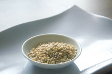Bowl of organic pearl barley on white plate
