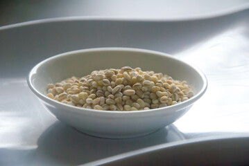 Bowl of organic pearl barley on white plate