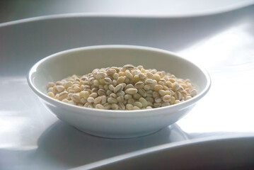 Bowl of organic pearl barley on white plate