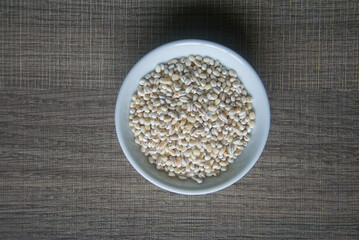 Bowl of organic pearl barley on white plate