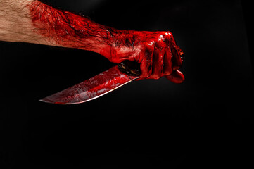 Man holding knife with bloody hand on black background. 
