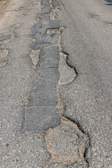An old paved road with a lot of holes and damage