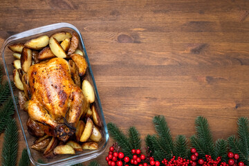 Christmas baked chicken on wooden table with copy space, top view