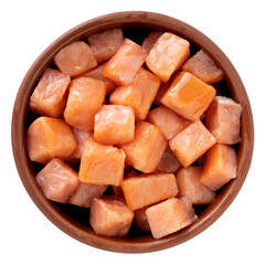 Salmon cut into small cubes in a bowl isolated on a white background, top view
