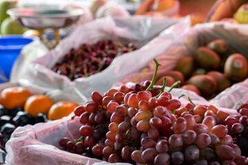 Grapes on a Fruit stall in the Market with a variety of fruit in the background