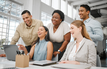Cheerful, joyful professional business people looking at laptop, browsing funny videos online and bonding on break in office at work. Corporate, diverse and young colleagues searching the internet