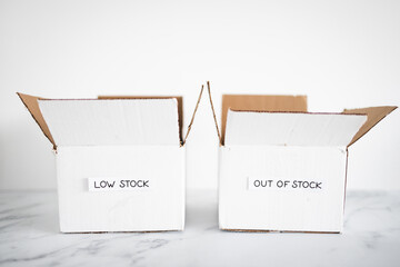 Low stock and out of stock texts on white delivery parcels on white background, supply chain...