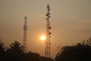 video of the Base Transceiver Station mast standing among the trees with a beautiful sunrise in the...