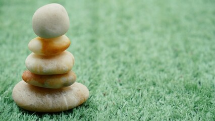 Fototapeta na wymiar The Balance Stones are stacked as pyramids in a soft natural bokeh background, representing the calm philosophical concept of Jainism's wellness.