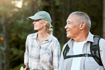 Mature man and woman hiking, smiling and looking at the view in nature. Fit local travel guide...