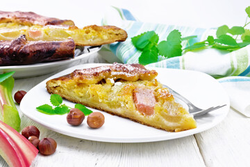 Tart with rhubarb and nut cream on light wooden board