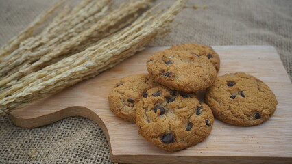 Chocolate cookies with on wooden cutting board and on burlap surface