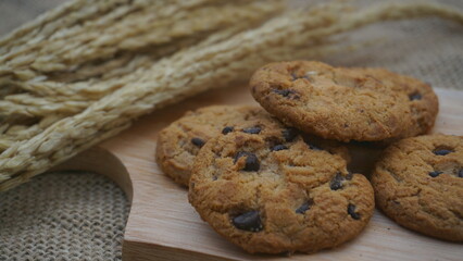 Chocolate cookies with on wooden cutting board and on burlap surface
