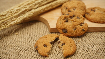 Chocolate cookies with on wooden cutting board and on burlap surface