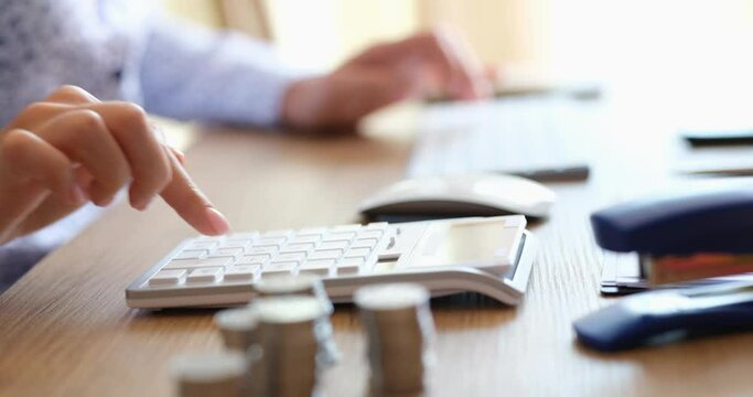 Business person presses buttons of computer keyboard and calculator in analysis of business and financial information