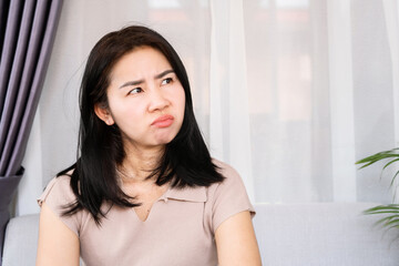 Naklejka premium angry Asian woman with unhappy face having mood swings caused by PMS or Premenstrual Syndrome