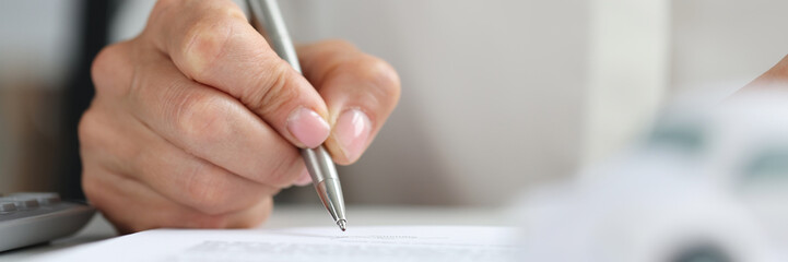 Hands of client signing car rental form closeup