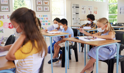 ... Learning, covid teaching and studying young students sitting in a school classroom indoors....