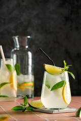 Refreshing summer mojito cocktail with ice cubes, fresh mint and lime on black. Exotic mojito beverage