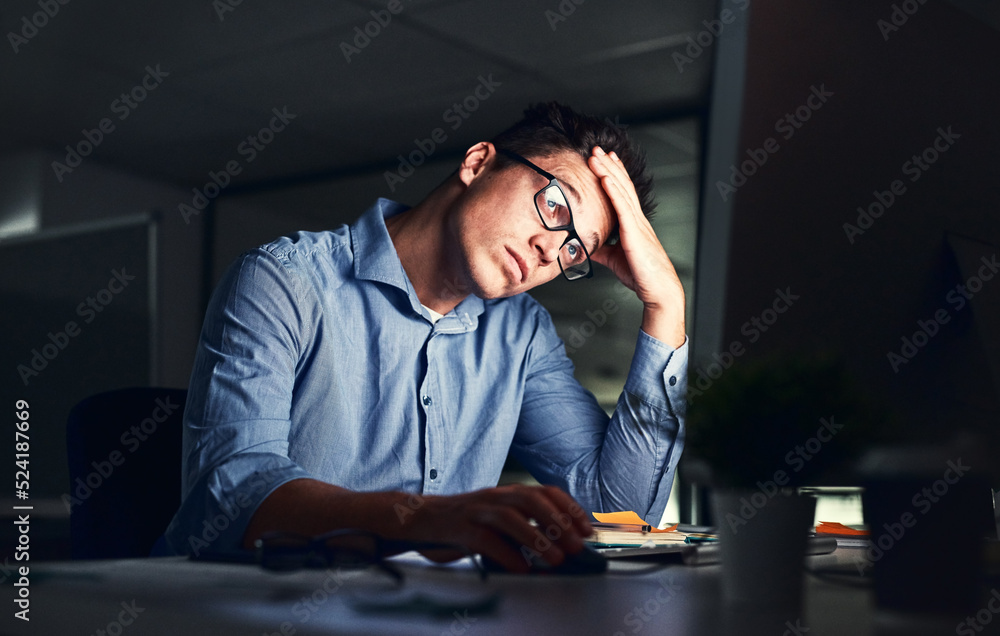 Poster Tired, stressed businessman suffering from headache, working late night in the office. Serious, frustrated and overworked corporate male with headache staring at his screen in the dark.