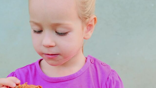 portrait of a pretty little kid girl eating fried crispy crunchy chicken meat