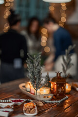 set of burning candles, small artificial Christmas trees and plates with spices on a wooden brown table, Christmas and New Year's concept, selective focus