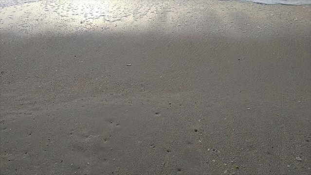 Soft ocean wave on clean sandy beach