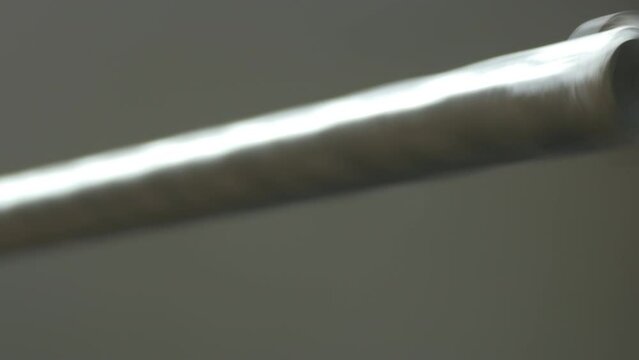 A large drill bit for drilling reinforced concrete rotates in the chuck of the impact drill on white background.

Unmodified camera color.