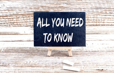ALL YOU NEED TO KNOW text on the Miniature chalkboard on wooden background
