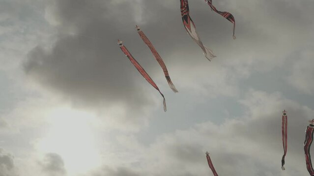 Balinese Traditional Kites JANGGAN (Red White Black Long Tail Bird Dragon) on Bali Kite Festival Summer Blue Sky Slow Motion