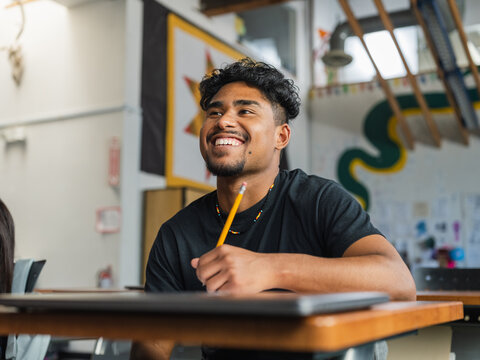Native boy with curly hair smiles big during class