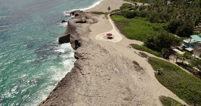 Aerial view over rocky coast and the Paseo Tablado de Isabela park in sunny Puerto Rico, USA - tilt, drone shot