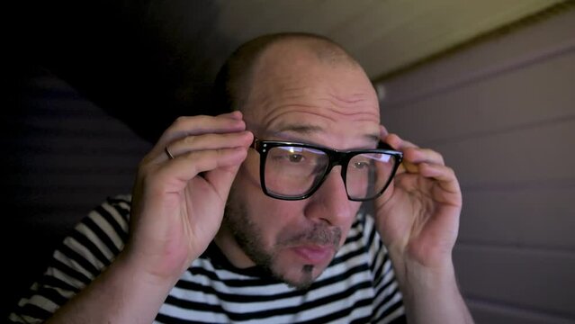 Man staring at monitor and putting on glasses with surprize. 4k video footage