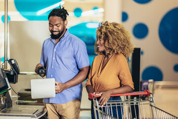 African American Couple buying food at grocery store or supermarket self-checkout