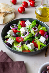 Greek salad with feta cheese, tomatoes, cucumbers, peppers and Kalamata olives. Healthy eating. Vegetarian food.