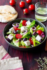 Greek salad with feta cheese, tomatoes, cucumbers, peppers and Kalamata olives. Healthy eating. Vegetarian food.