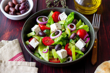 Greek salad with feta cheese, tomatoes, cucumbers, peppers and Kalamata olives. Healthy eating. Vegetarian food.