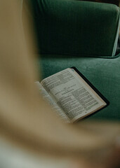 The Christian Holy Bible Scripture open to the Book of Colossians on a green background with a...
