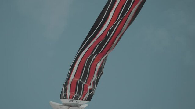 Balinese Traditional Kites JANGGAN (Red White Black Long Tail Bird Dragon) on Bali Kite Festival Summer Blue Sky Slow Motion