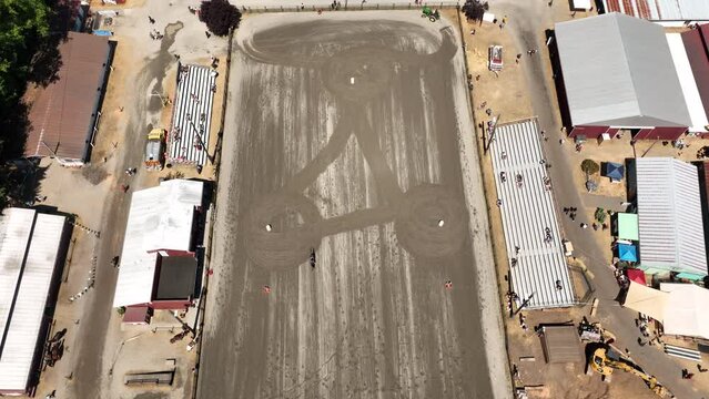 Top down aerial view of a horse competing in a time trial at the local rodeo.