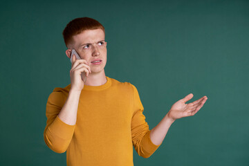 Ginger male student holding and showing mobile phone