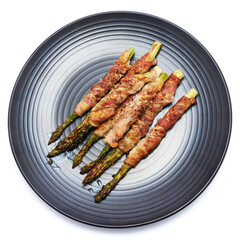 baked aspargus covered with bacon on ceramic plate isolated on white background