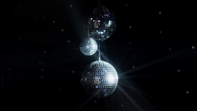 Disco Ball with Reflected Moving Rays Rotating. Mirror disco ball in white light. Isolated disco ball on black background. Close-up. Mirror ball spinning indoors. Performance. The reflection of lights