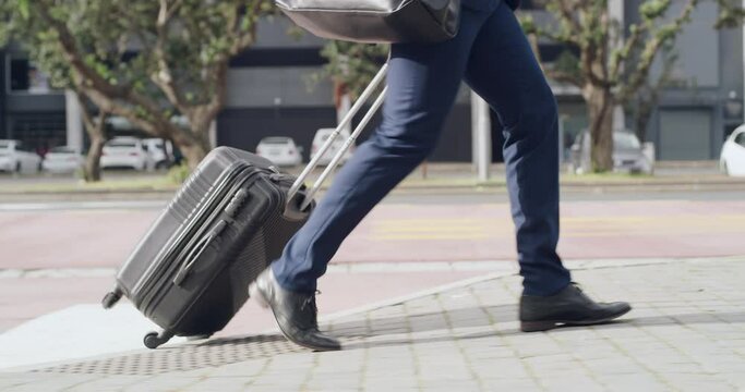 Corporate traveling businessman walking and carrying a suitcase in street of urban city town on his way to the airport. Modern executive employee on his way to catch business trip flight with luggage