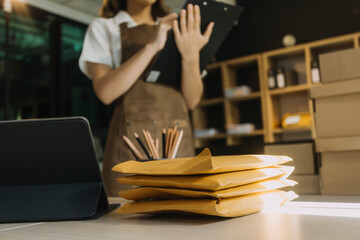 Portrait of Starting small businesses SME owners, two Asian woman check online orders Selling products working with boxs freelance work at home office, sme business online small medium enterprise