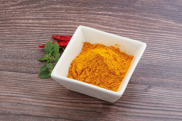 Yellow vibrant curcuma powder in the bowl