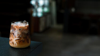 Ice coffee on a table with cream being poured into it showing the texture
