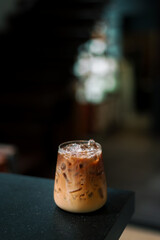 Ice coffee on a table with cream being poured into it showing the texture