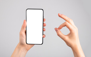 Woman holding phone mockup and showing ok gesture. Application, website recommendation, approval. Android template with blank display.