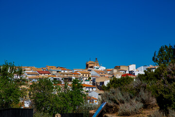 Paisaje urbano de pueblo con castillo e iglesia de fondo